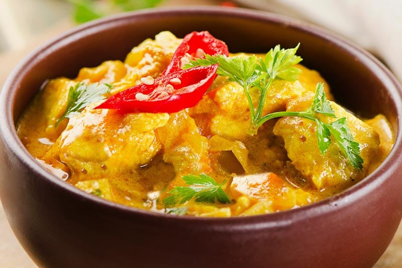 Chicken curry with parsley in bowl